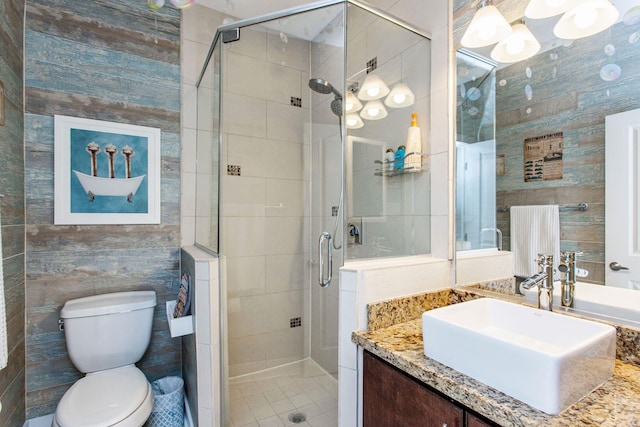 full bathroom featuring vanity, tile walls, toilet, and a stall shower