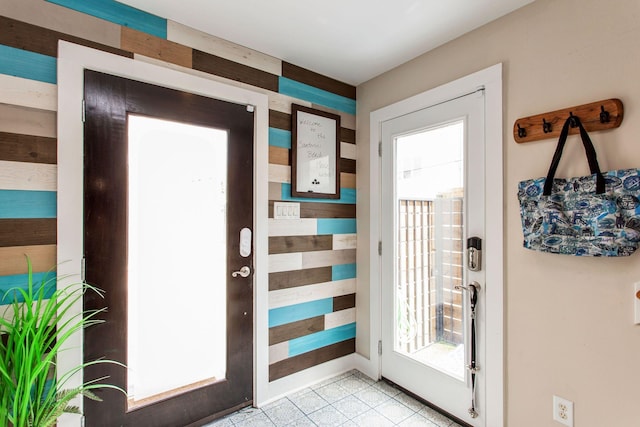 doorway to outside with light tile patterned floors and baseboards