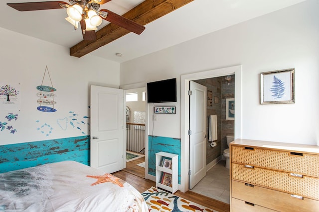 bedroom featuring ceiling fan, beamed ceiling, light wood-style flooring, and ensuite bathroom