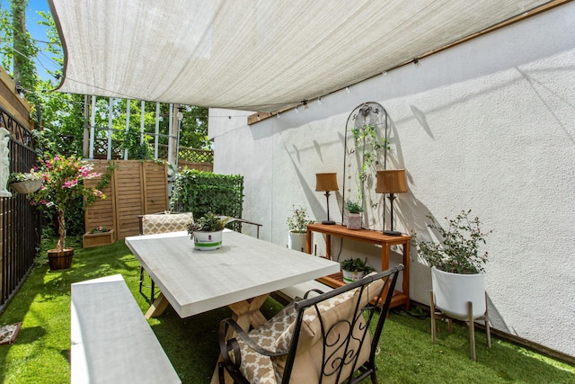 view of patio with outdoor dining space and fence