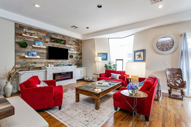 living area featuring recessed lighting, wood finished floors, and a fireplace