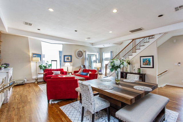 dining room featuring visible vents, wood finished floors, and stairway