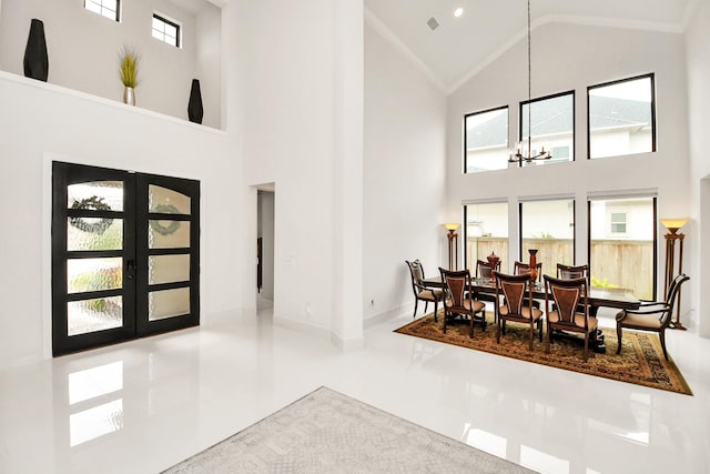 dining space featuring baseboards, high vaulted ceiling, french doors, and an inviting chandelier