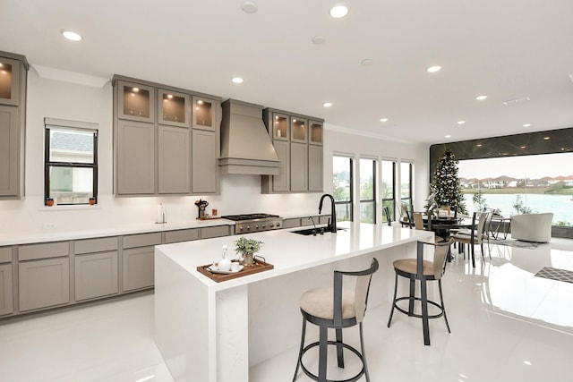 kitchen with a sink, premium range hood, gray cabinets, and recessed lighting