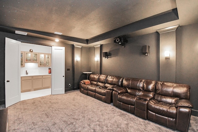 carpeted home theater room featuring wet bar