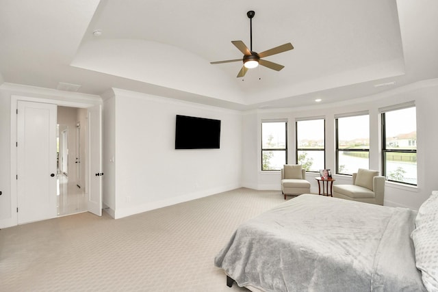 bedroom featuring lofted ceiling, a raised ceiling, a ceiling fan, light carpet, and baseboards