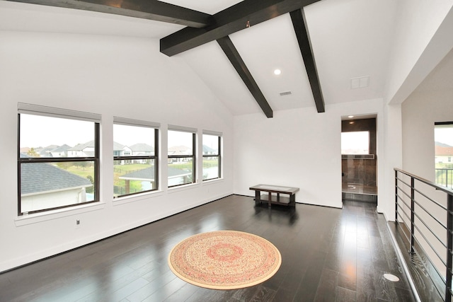 empty room with high vaulted ceiling, beamed ceiling, and wood finished floors