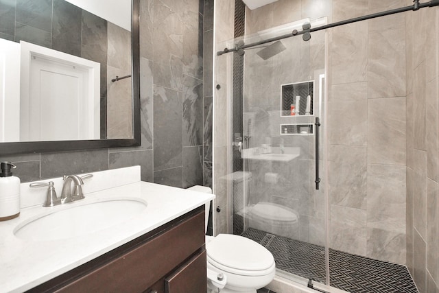 bathroom with tile walls, decorative backsplash, toilet, a shower stall, and vanity