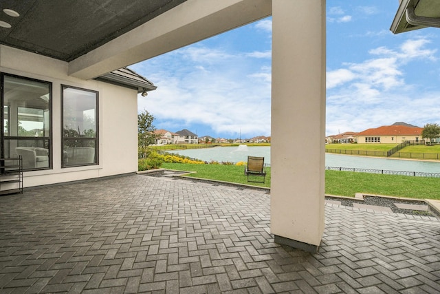 view of patio with a water view, a residential view, and fence