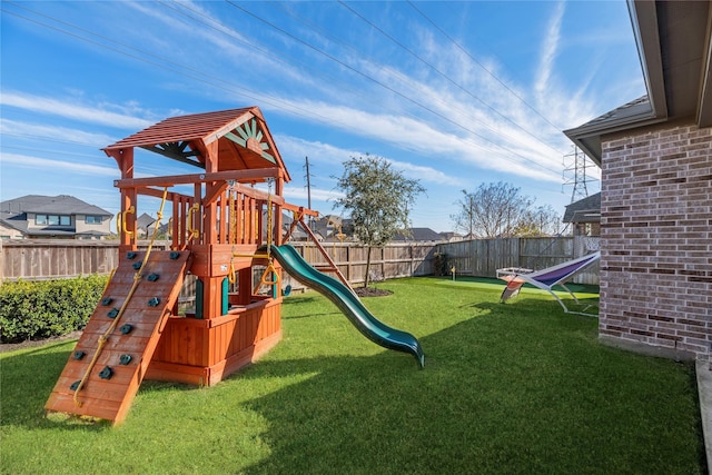 view of playground featuring a lawn and a fenced backyard