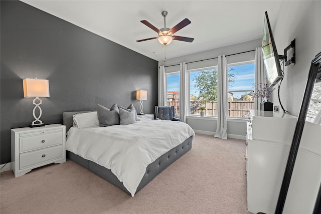 bedroom featuring a ceiling fan, lofted ceiling, light colored carpet, and baseboards