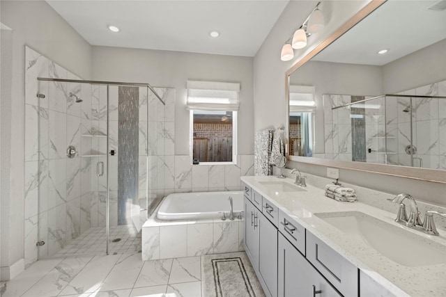 bathroom with double vanity, a garden tub, a marble finish shower, and a sink