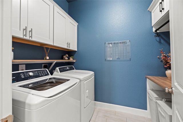 laundry area with cabinet space, light tile patterned floors, baseboards, and separate washer and dryer