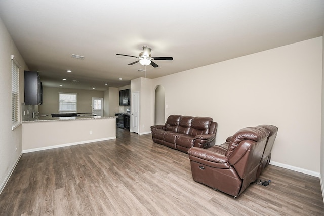 3734 Giorgio Pastel Pl, Katy, TX 77493 - living room featuring dark wood finished floors, ceiling fan, arched walkways, and baseboards