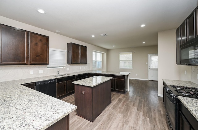 3734 Giorgio Pastel Pl, Katy, TX 77493 - kitchen featuring light wood-type flooring, black appliances, tasteful backsplash, a peninsula, and dark brown cabinets