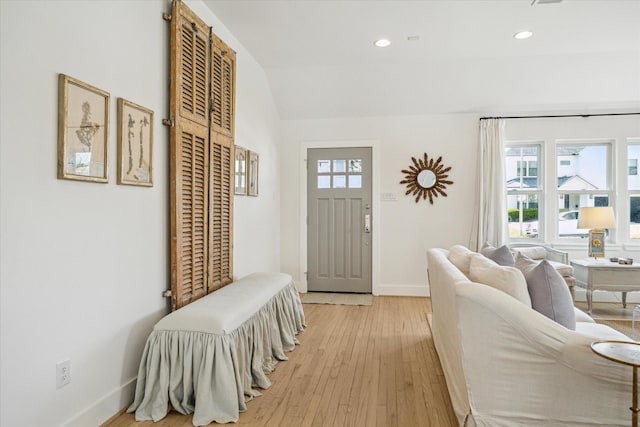 foyer featuring light wood-style flooring, baseboards, vaulted ceiling, and recessed lighting