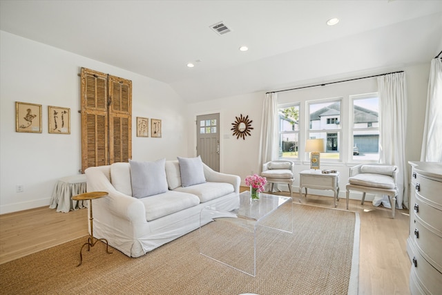 living area with light wood finished floors, lofted ceiling, recessed lighting, visible vents, and baseboards