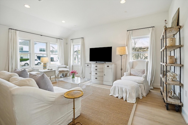 living room featuring light wood-style floors, vaulted ceiling, a wealth of natural light, and recessed lighting