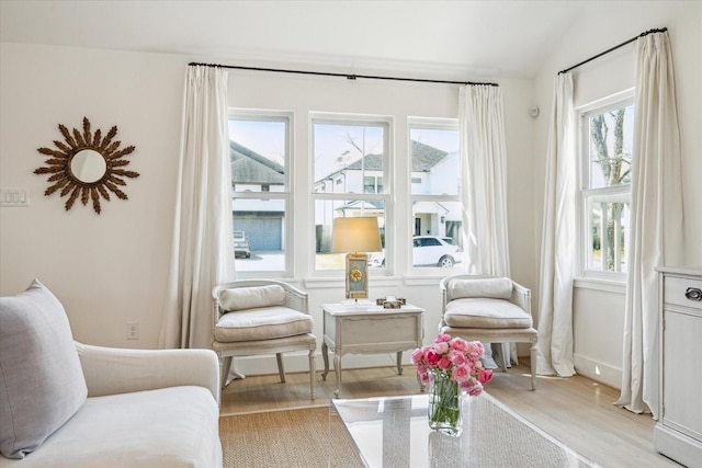 sitting room with lofted ceiling, baseboards, and wood finished floors