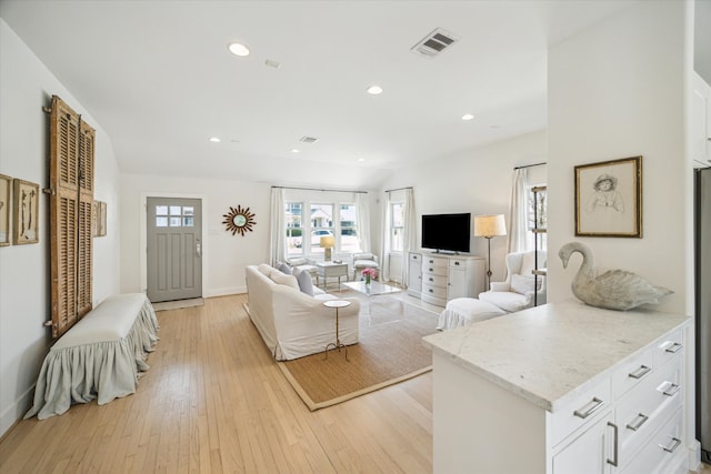 living room featuring baseboards, light wood finished floors, visible vents, and recessed lighting