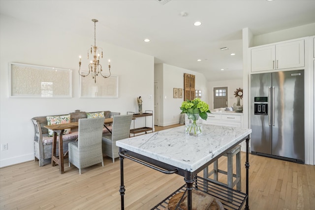 kitchen featuring recessed lighting, white cabinetry, baseboards, high end fridge, and light wood-type flooring