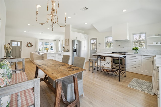 dining space featuring light wood-style floors, recessed lighting, visible vents, and plenty of natural light