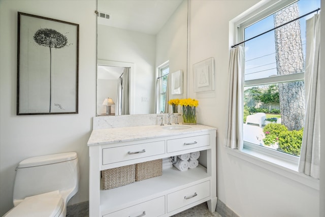 bathroom with toilet, baseboards, visible vents, and vanity