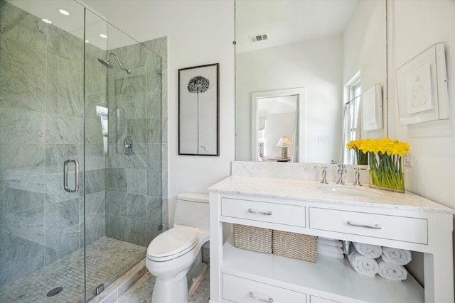 full bath with toilet, a stall shower, vanity, and visible vents