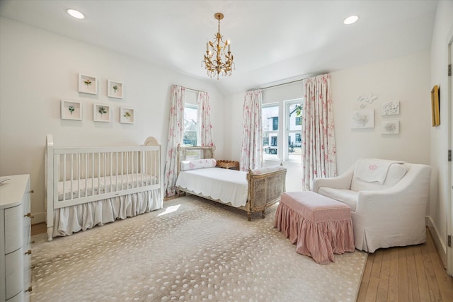 bedroom featuring recessed lighting, a notable chandelier, and wood finished floors