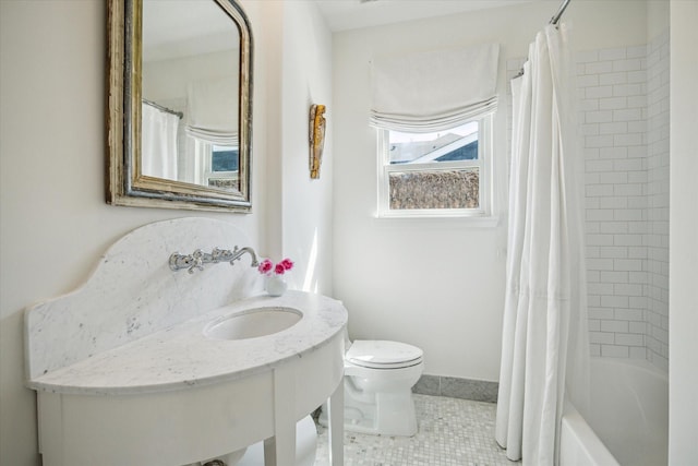 bathroom with toilet, shower / tub combo, a sink, baseboards, and tile patterned floors