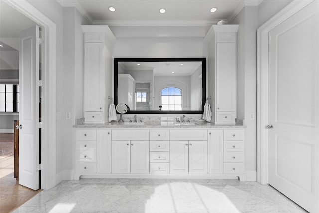 bathroom featuring marble finish floor, ornamental molding, a sink, and recessed lighting