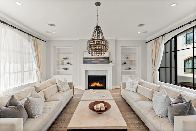 living area featuring ornamental molding, built in shelves, a glass covered fireplace, and visible vents