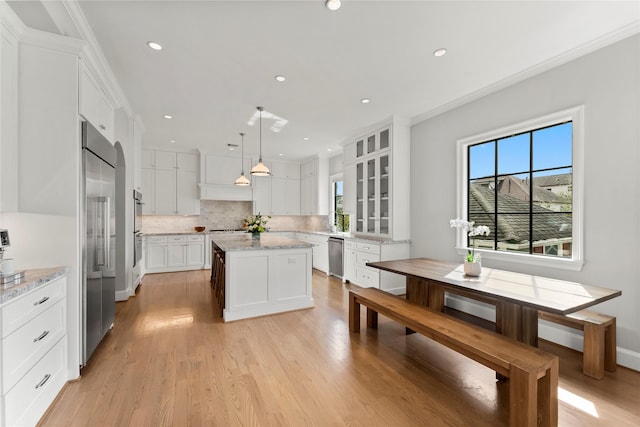 kitchen featuring ornamental molding, stainless steel appliances, tasteful backsplash, and white cabinets