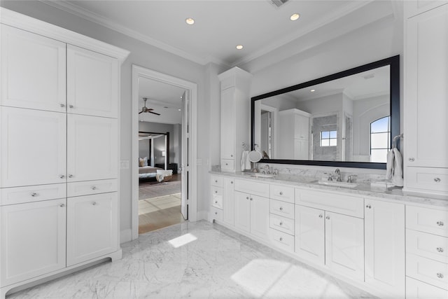 full bath with double vanity, marble finish floor, crown molding, and a sink