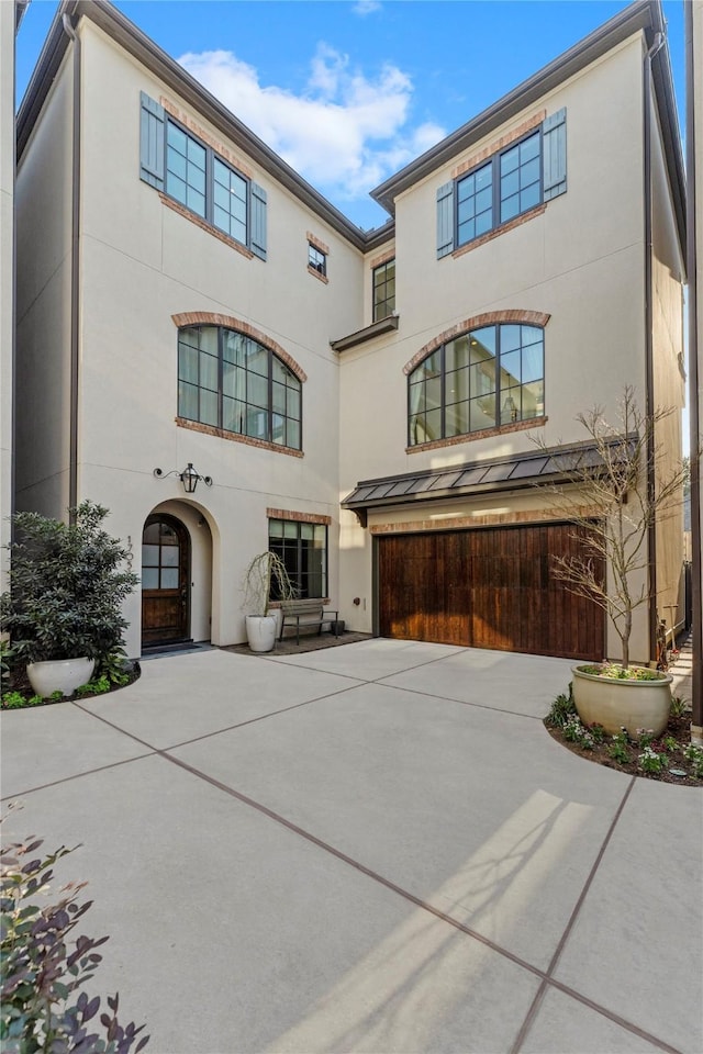 view of front of house featuring driveway, a garage, and stucco siding