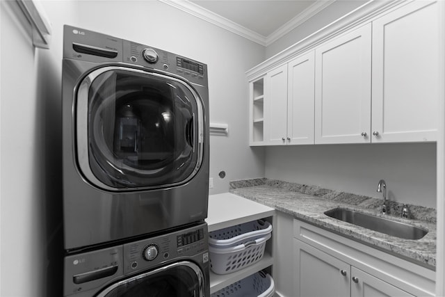 laundry room featuring a sink, cabinet space, ornamental molding, and stacked washer / dryer