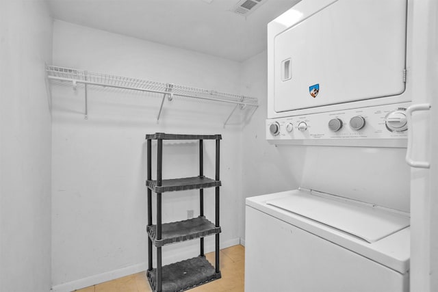 washroom with stacked washer / drying machine, laundry area, visible vents, and baseboards