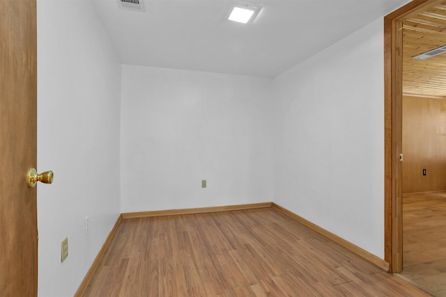 unfurnished room featuring visible vents, baseboards, and wood finished floors