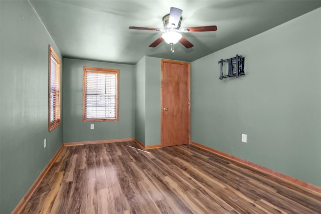 unfurnished bedroom with ceiling fan, baseboards, and wood finished floors