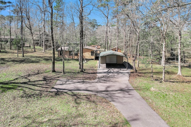 view of front of home featuring aphalt driveway, a detached carport, and an outdoor structure