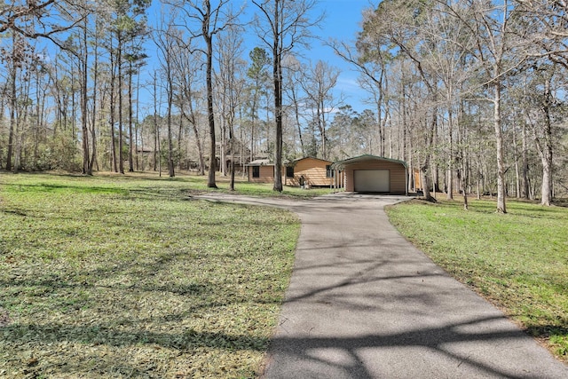 exterior space with a garage, a lawn, and a carport