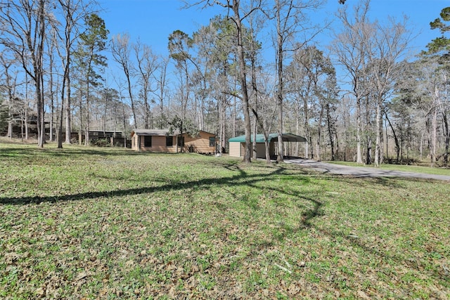 view of yard featuring a detached carport and an outdoor structure