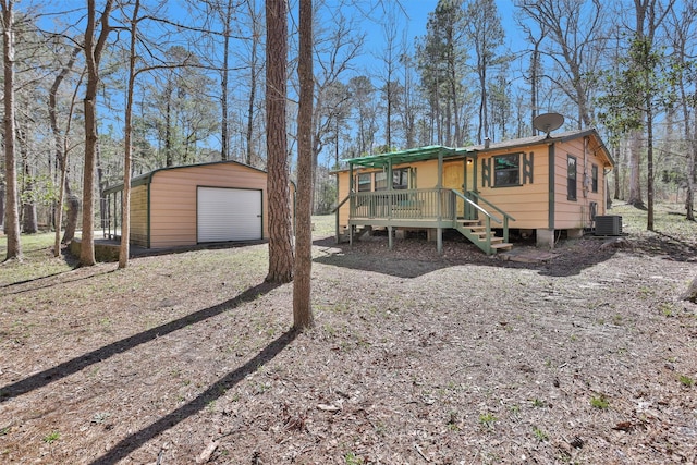 view of front facade with dirt driveway, a detached garage, and an outdoor structure