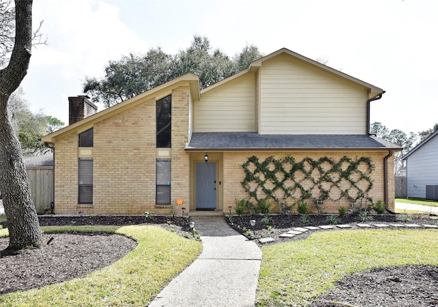 mid-century inspired home featuring a front yard, roof with shingles, a chimney, and brick siding