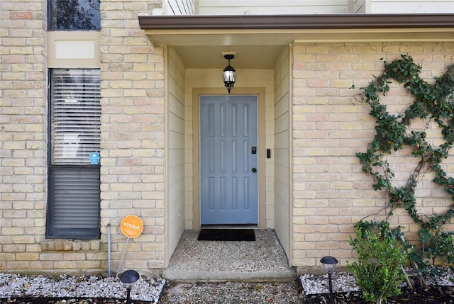 doorway to property featuring brick siding