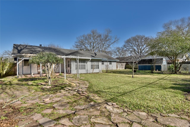 back of property with a yard, fence, and stucco siding