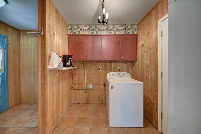 clothes washing area with light tile patterned floors, wood walls, cabinet space, and washer / dryer