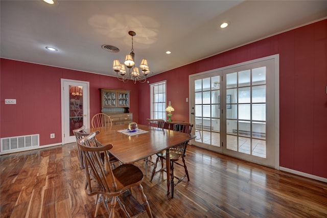 dining room with a notable chandelier, visible vents, and wood finished floors