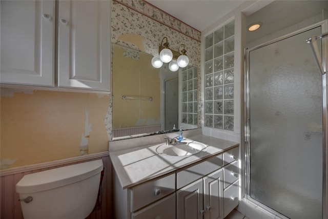 full bath with wallpapered walls, a shower stall, toilet, and vanity