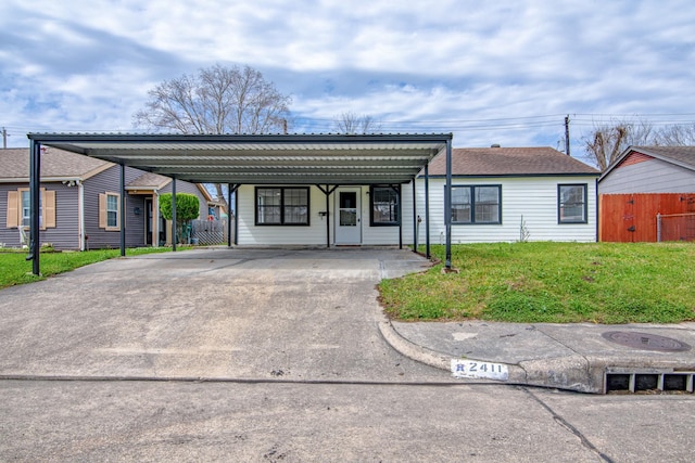 view of front of home featuring a carport, fence, driveway, and a front lawn